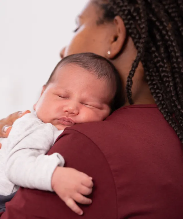 Baby sleeping on mom's shoulder.